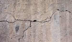 Cracked concrete wall highlighting foundation issues related to basement waterproofing and structural integrity.